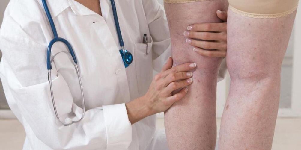 O médico examina as pernas do paciente